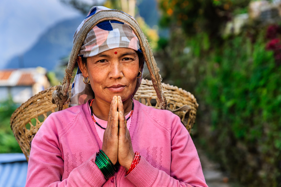 Nepali woman saying Namaste near Annapurna Range